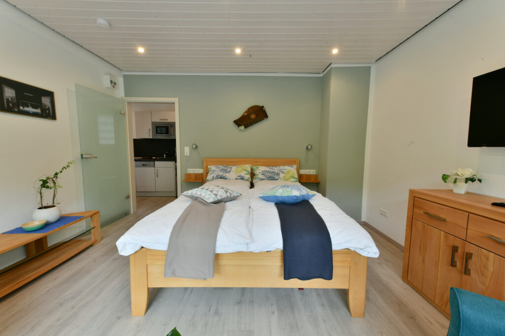 Tweepersoonsbed in Lohengrin met een houten kast ernaast
