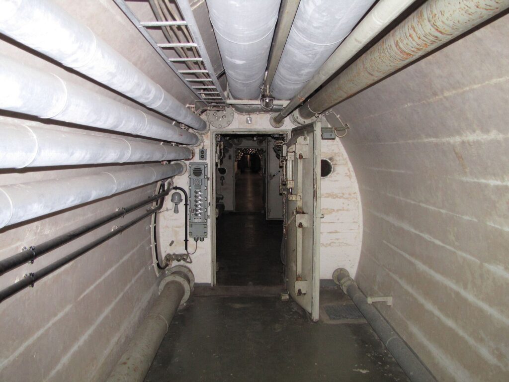 Gang met leidingen langs het gewelf en een zware stalen deur in de Bundesbank-Bunker onder Cochem