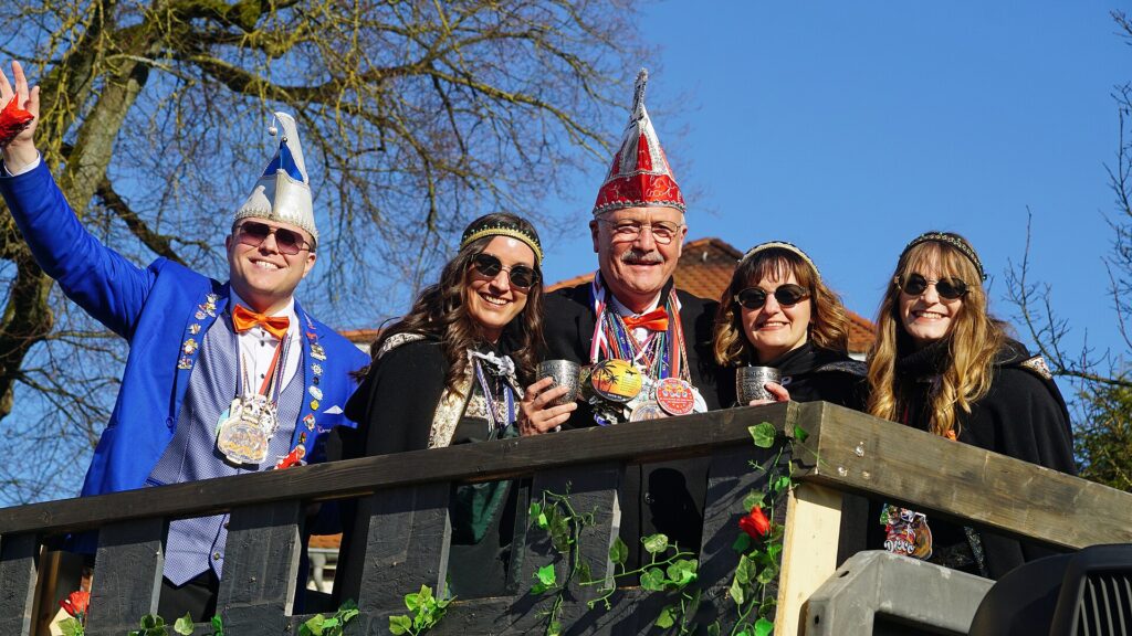 Carnavalsoptocht met een versierde praalwagen en verklede feestvierders