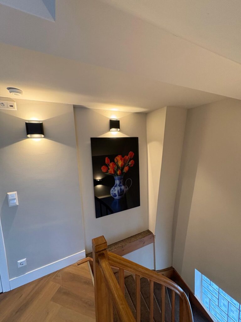 Overloop bij de trap met een schilderij van tulpen
