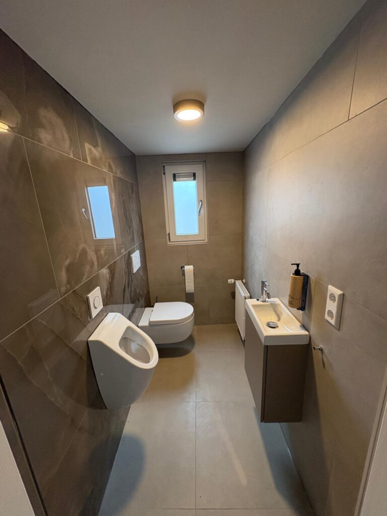 Toiletruimte met urinoir, toilet en wastafel