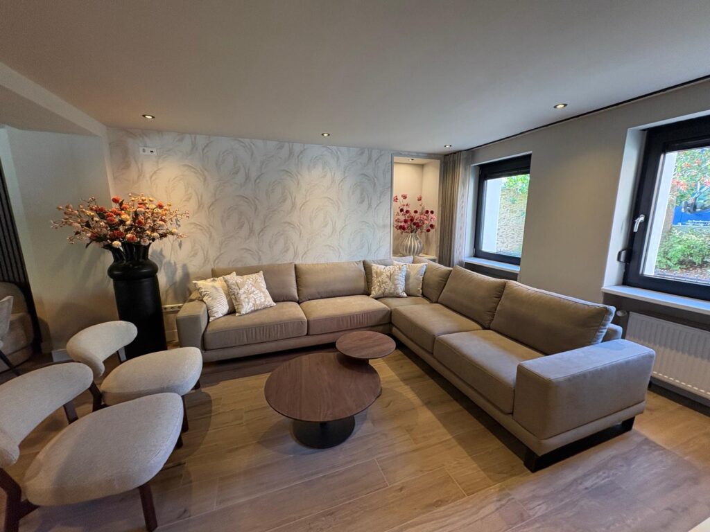 Woonkamer van Ahrt Villa met grote hoekbank, fauteuils en ronde salontafels